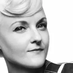 En kvinna med en elegant bea szenfeld frisyr, markerad eyeliner och en septumring.