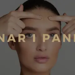 En kvinna undersöker sina finnar i pannan. Texten "FINNAR I PANNAN" visas över bilden.
