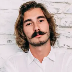 Ung man med långt hår och en imponerande mustasch som visar upp olika mustasch stilar.