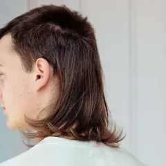 Profilbild på en person med en modern mullet. Håret är mörkbrunt och stylat med kortare topp och längre nacke.