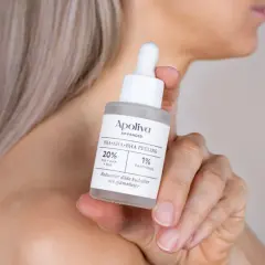 En hand håller en flaska med Apoliva PHA+AHA+BHA Peeling. Denna aha syra-produkt hjälper till att reducera döda hudceller.
