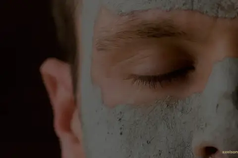 Närbild på ett ansikte med en lermask som rengör porerna.