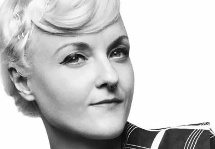 En kvinna med en elegant bea szenfeld frisyr, markerad eyeliner och en septumring.