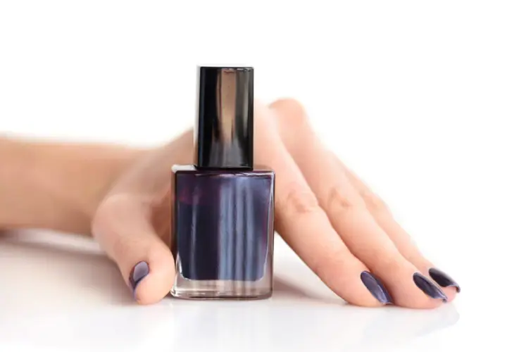 Mörkblått nagellack i en flaska, med en hand som visar matchande naglar. Perfekt för att torka nagellack snabbt.