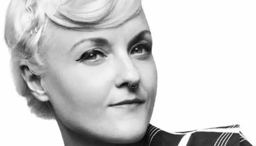 En kvinna med en elegant bea szenfeld frisyr, markerad eyeliner och en septumring.