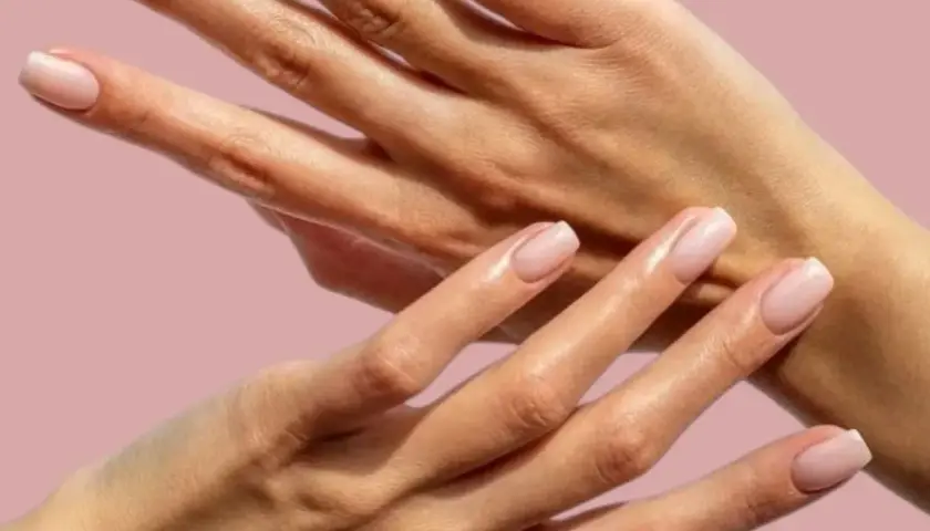 Två händer med perfekt manikyrerade naglar och mjuka nagelband. En dröm för alla med fnasiga nagelband.