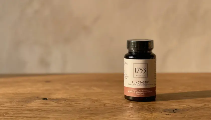 En mörk flaska med "1753 LIFESTYLE FUNGTASTIC" och text om kollagen hudvård.