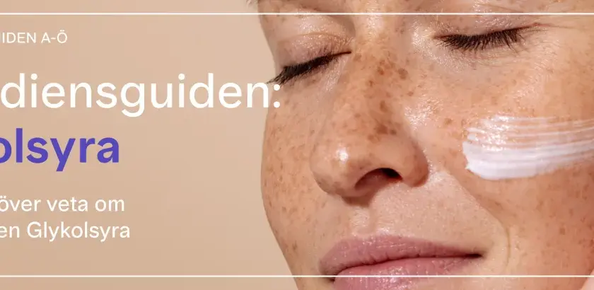 En närbild av en kvinna med fräknar som får en kräm med glykolsyra på kinden. Texten "Ingrediensguiden: Glykolsyra" syns tydligt.