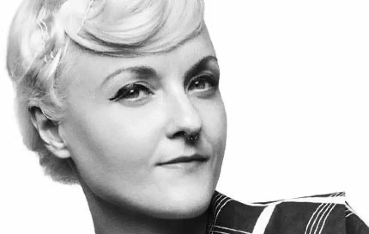 En kvinna med en elegant bea szenfeld frisyr, markerad eyeliner och en septumring.