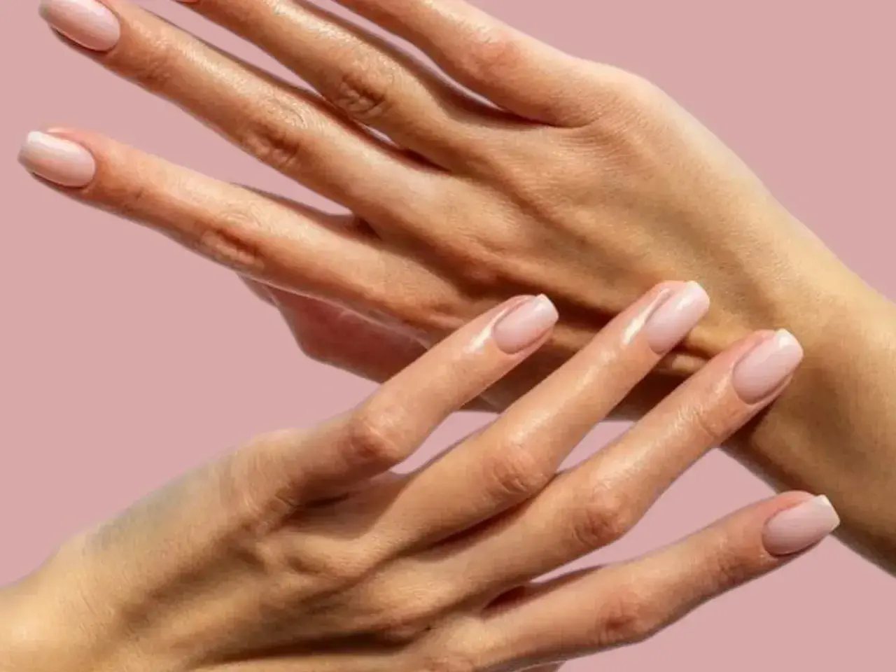 Två händer med perfekt manikyrerade naglar och mjuka nagelband. En dröm för alla med fnasiga nagelband.