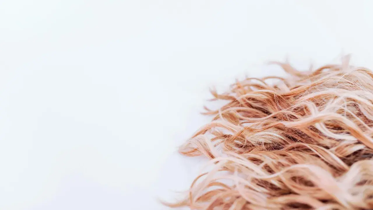 Ljust, lockigt hår som ser ut att ha fått en behandling med hair botox för extra glans och mjukhet.