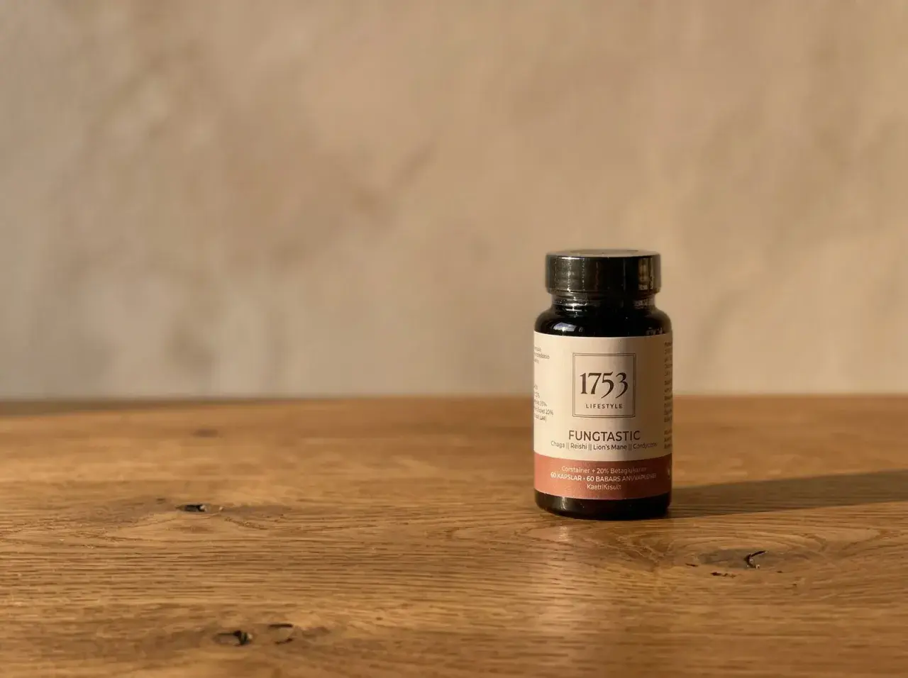 En mörk flaska med "1753 LIFESTYLE FUNGTASTIC" och text om kollagen hudvård.