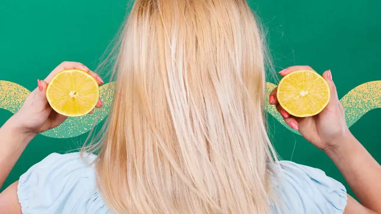 Kvinnan med blont h&aring;r h&aring;ller upp citronhalvor vid &ouml;ronen, som om hon vill bleka h&aring;ret med citron.