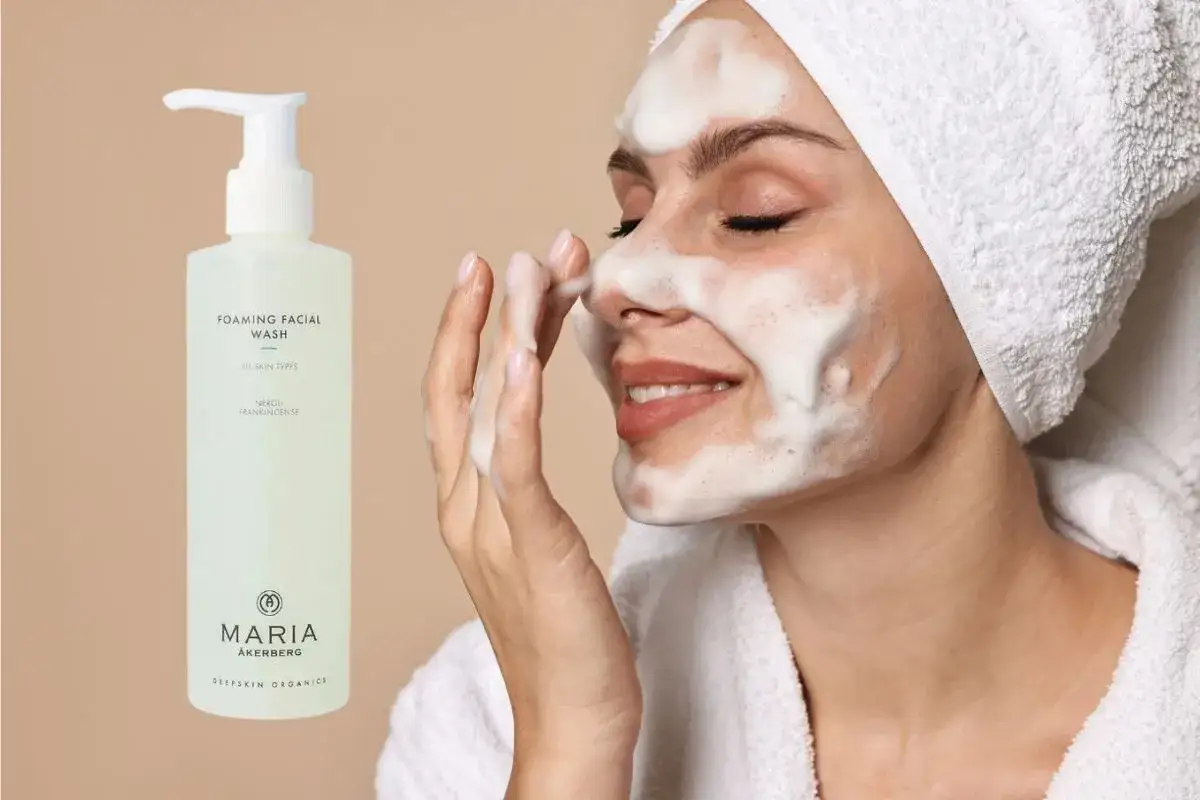 En kvinna med skum i ansiktet njuter av sin rengöringsrutin med Maria Åkerberg foaming facial wash.